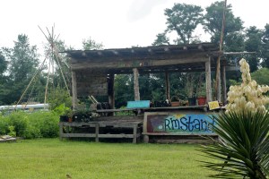 Front of the farmstand where potted plants, produce and handmade items are displayed